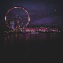 Illuminated ferris wheel at night