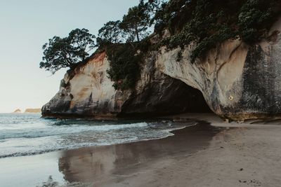 Rock formation on beach against sky