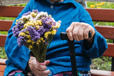 Senior people support. charities for elderly people. close up of senior woman hands with flowers