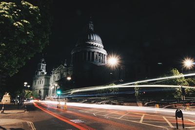 Road passing through illuminated city at night