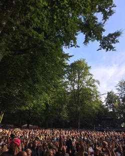 Crowd at music concert against sky