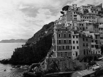 Buildings by sea against sky