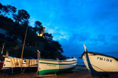 View of boats in sea against cloudy sky