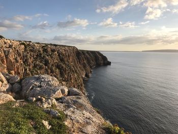 Rock formations by sea against sky