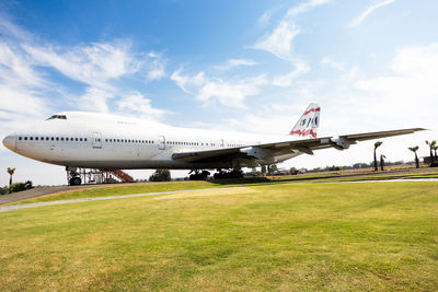 Airplane on airport runway against sky