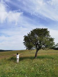 Woman standing on field against sky