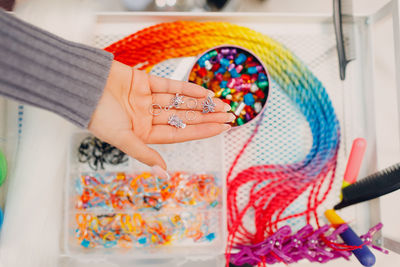 Cropped hand of woman holding multi colored decoration