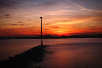 Scenic view of lake against romantic sky at sunset