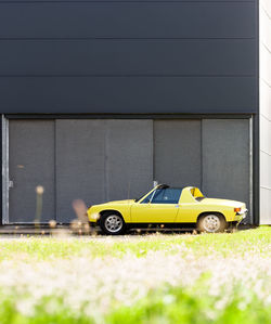 Car parked against yellow wall
