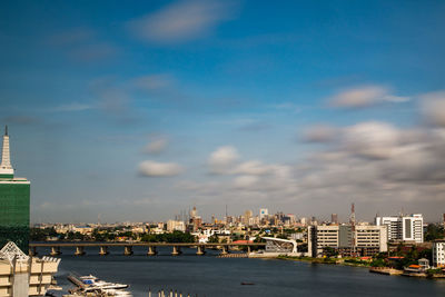 Buildings by sea against sky in city