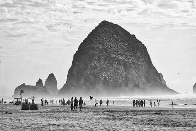 People at beach against sky