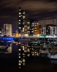 Illuminated buildings against sky at night