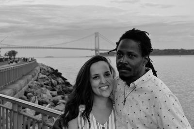 Couple standing by railing against bridge