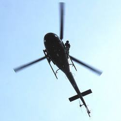 Low angle view of helicopter flying against clear sky