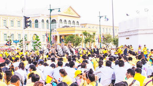 People walking on street against buildings in city