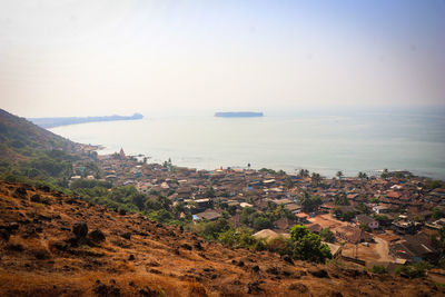 Scenic view of sea by buildings against clear sky