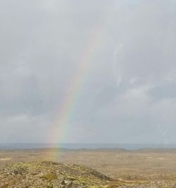 Rainbow over landscape against sky