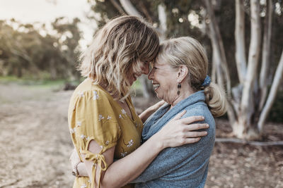 Lifestyle portrait of adult mother and senior mother smiling