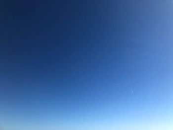 Low angle view of moon against blue sky