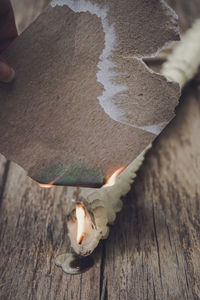 Cropped image of hand holding lit candle