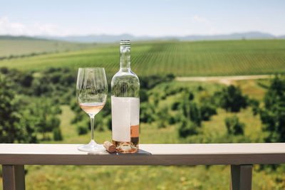 Wine glasses on table against sky on field