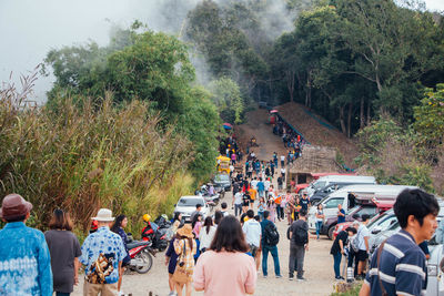 People on footpath against trees during winter