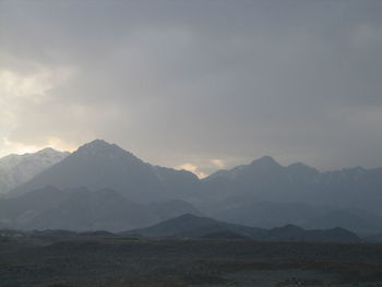 Scenic view of mountains against cloudy sky