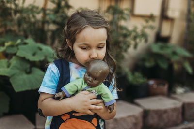 Close-up of cute girl holding baby while standing outdoors