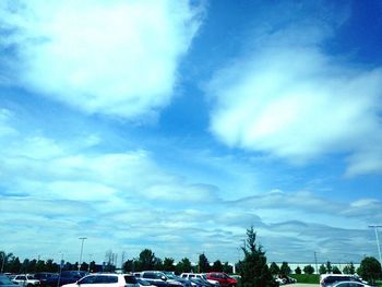 Cars on road against cloudy sky