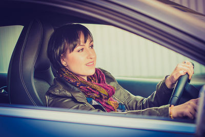 Portrait of smiling woman sitting in car