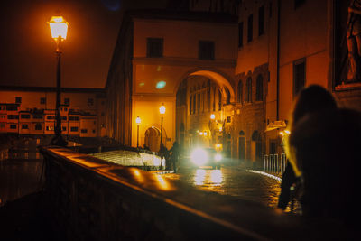 Rear view of man walking on street at night