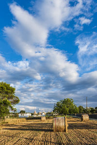 Hay bales on field against sky