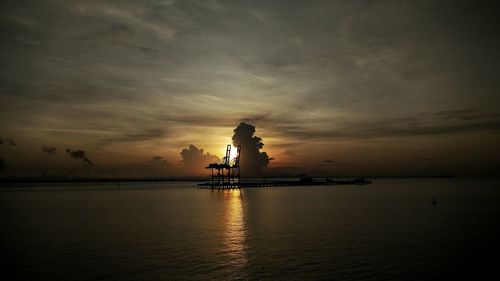 Silhouette ship in sea against sky during sunset