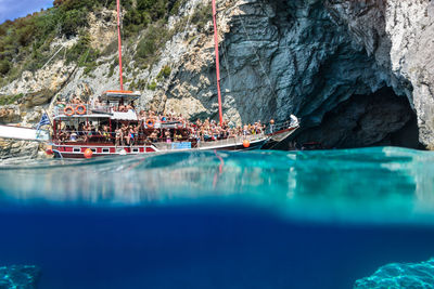 Ship sailing on sea by cave