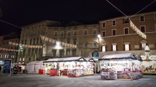 Cars on street against illuminated buildings in city at night