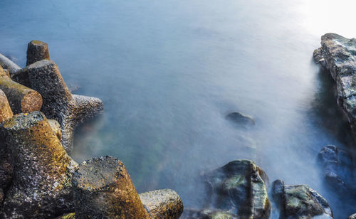 Rock formation in sea against sky