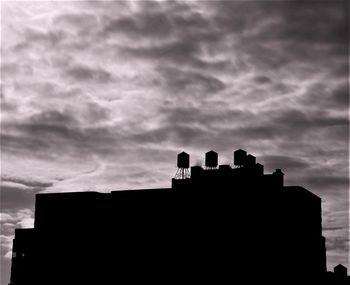 Low angle view of silhouette buildings against sky
