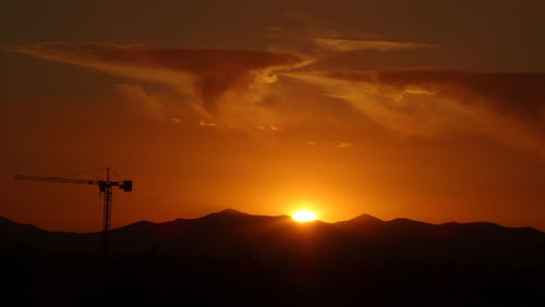 Silhouetted mountains against orange sky