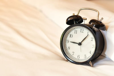 Close-up of clock on bed