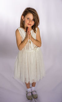 Portrait of a girl standing against wall