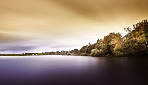 View of calm lake against cloudy sky