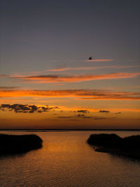 Scenic view of sea against orange sky