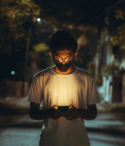 Young man wearing hat standing at night