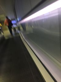 Blurred motion of man on illuminated railroad station platform