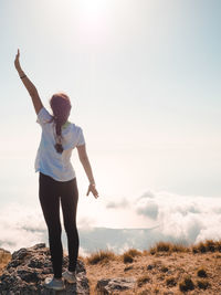 Full length of woman standing on land against sky during sunset