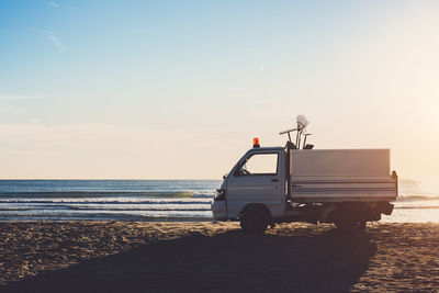 Car of cleaning service on the beach at sunrise