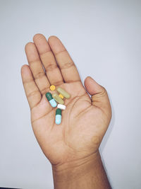 Close-up of hand holding paper over white background