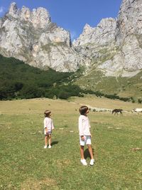 Boys looking away while standing on landscape