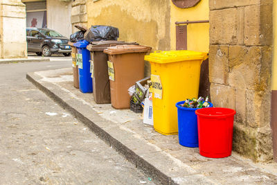 Garbage can on street against building