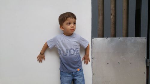 Boy standing against blue wall